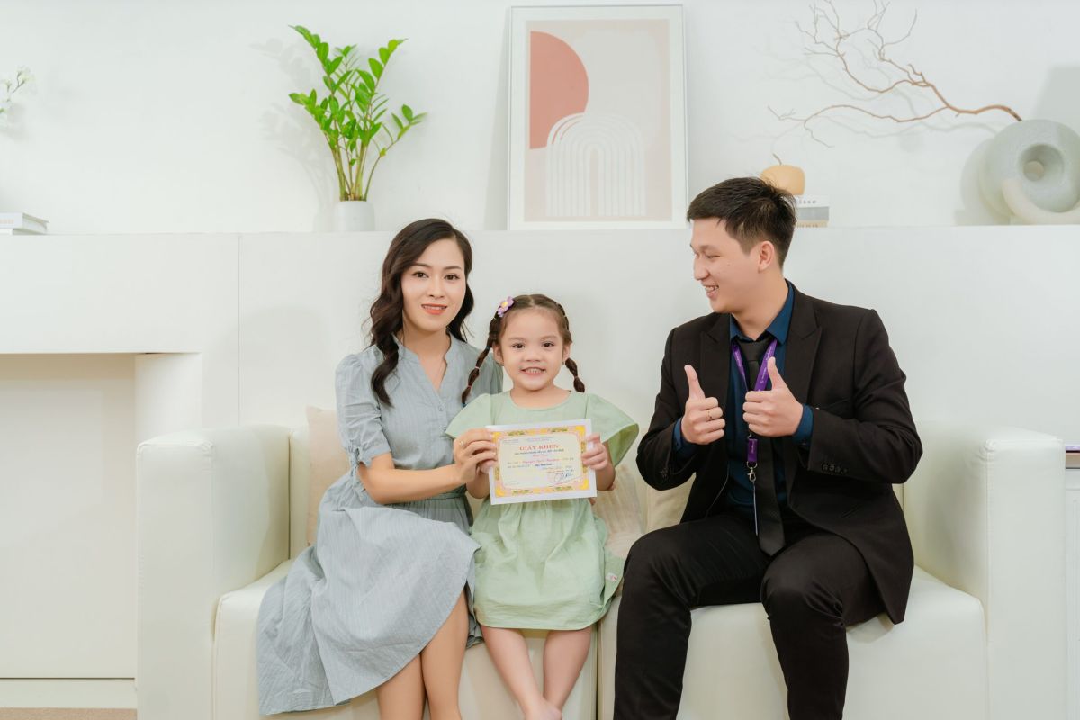 A family receiving an award with an eTeacher advisor